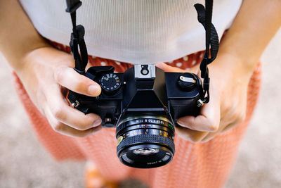 Midsection of woman holding camera