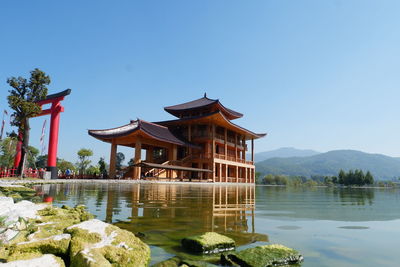 Gazebo in lake against clear sky