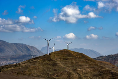 Wind turbines on land against sky