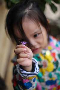 Close-up of young girl holding flower