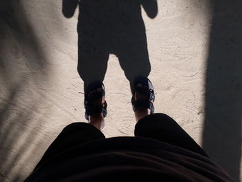 Low section of man standing at beach