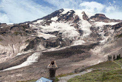 Rear view of woman on snowcapped mountains against sky