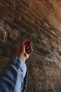 Midsection of person holding wall