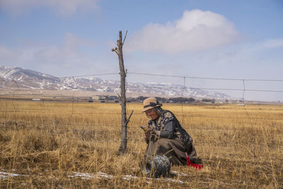 Woman cutting barbed wire on field