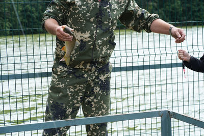 Midsection of man standing on railing