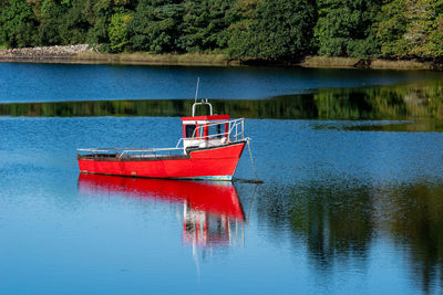 Red boat moored in lake