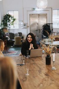 Portrait of happy woman sitting on table