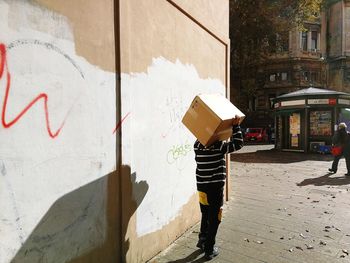 Full length of man standing by building in city