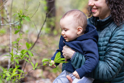 Portrait of cute girl blowing bubbles in forest