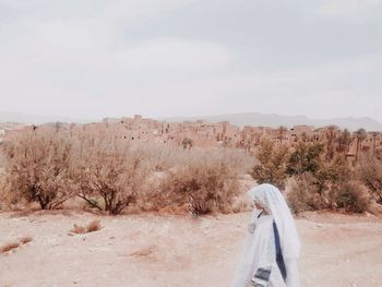 Low section of man in desert against sky