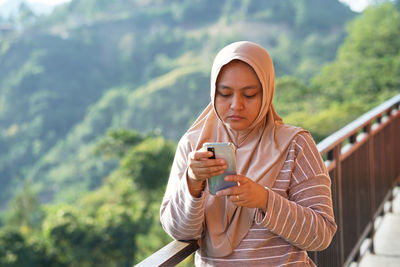 Portrait of young woman using mobile phone