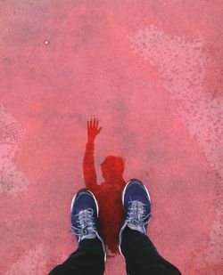 Low section of man standing on pink petals