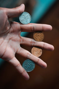 Close-up of hand holding coins