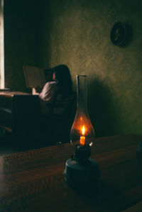 Rear view of woman sitting on table at home