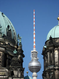 Communications tower in city against clear sky