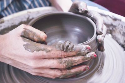 Cropped hands of woman making pottery