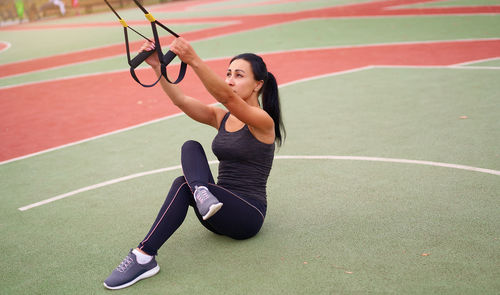 Full length of woman exercising at court