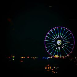 Low angle view of ferris wheel against sky at night