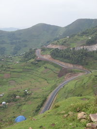 High angle view of road amidst field against sky