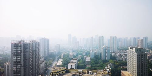 Aerial view of buildings in city against clear sky