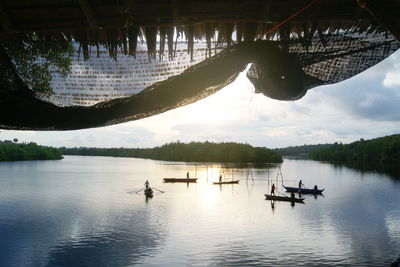 People in boat on river against sky