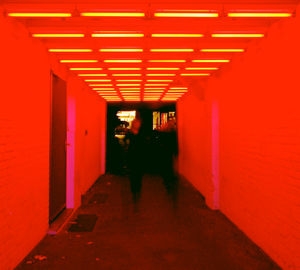 Narrow corridor along red orange wall