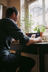 Male entrepreneur discussing with colleague on video call over laptop at home