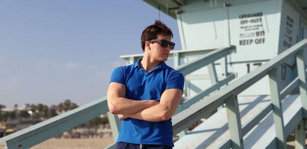 Young man standing against railing