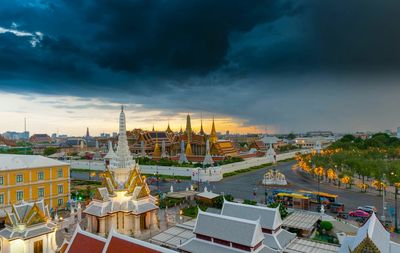 Grand palace and wat phra keaw against cloudy sky during sunset