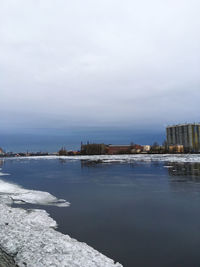 Buildings by sea against sky