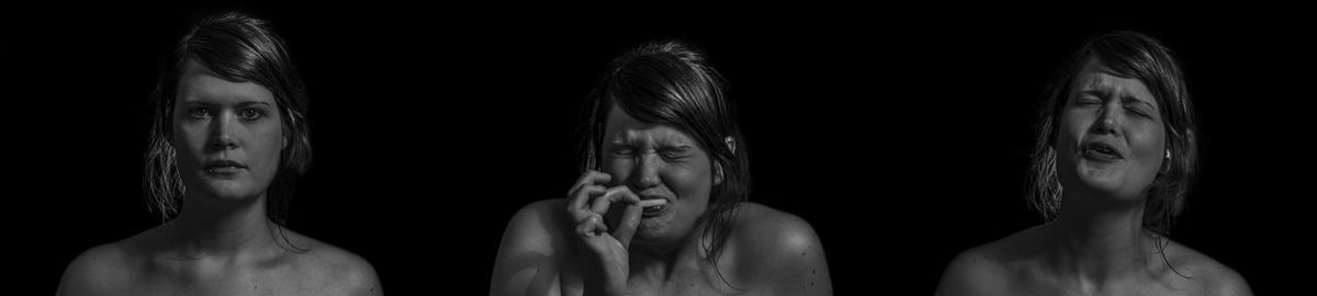 Close-up portrait of young woman against black background