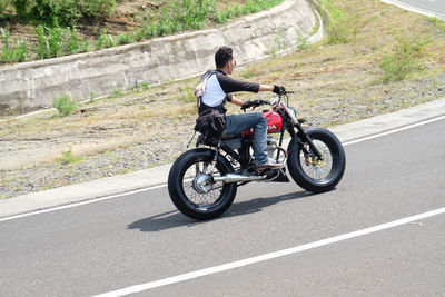 Rear view of man riding motorcycle