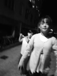 Midsection of woman standing on street in city at night