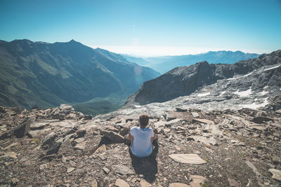 Rear view of woman standing on mountain against sky