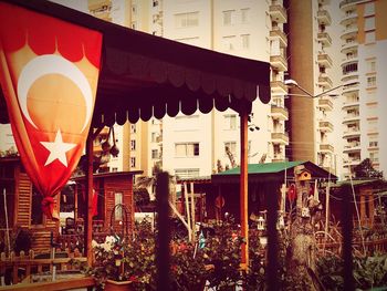 Low angle view of flags hanging amidst buildings in city