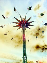 Low angle view of ferris wheel against cloudy sky