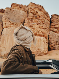 Rear view of man standing against rock formations