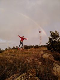 Scenic view of rainbow over field against sky