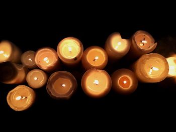 Close-up of candles over black background