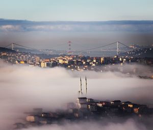 City under foggy weather against sky