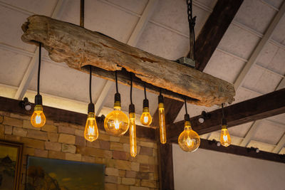 Low angle view of illuminated pendant light hanging from ceiling