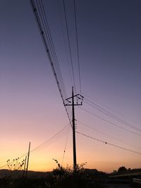 Low angle view of silhouette electricity pylon against romantic sky