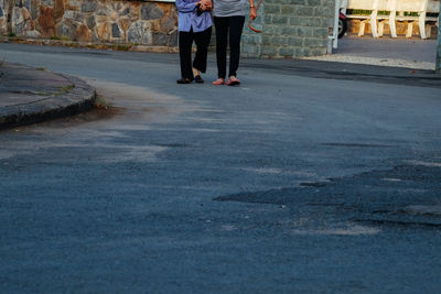 Low section of woman standing on road