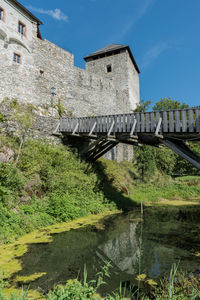 Low angle view of old building by bridge against sky