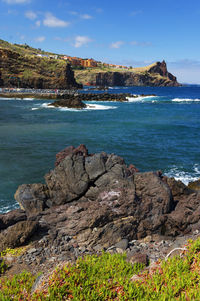 Calm blue sea against rocky landscape