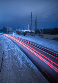 Light trails on road against sky in city