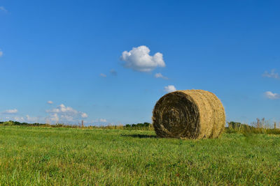 Hay bales on field against sky