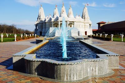 Fountain in front of temple against sky at simo