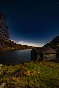 House on field against sky at night