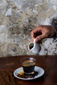 Hand holding coffee cup on table